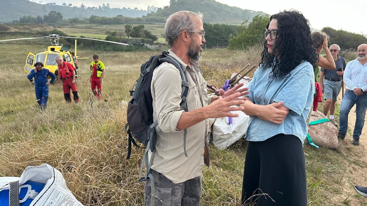 La consejera de Cultura se desplazó a Ribadesella y se reunió con responsables del equipo científico del MUJA. Detrás, el helicóptero.