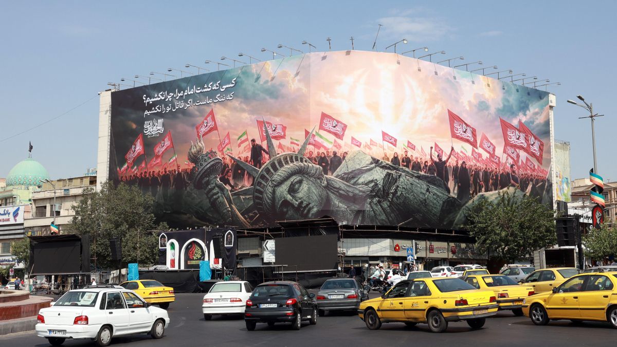 Vehículos pasan junto a una valla publicitaria antiestadounidense en la Plaza Enghelab, en el centro de Teherán, Irán, este domingo 9 de agosto de 2026. 