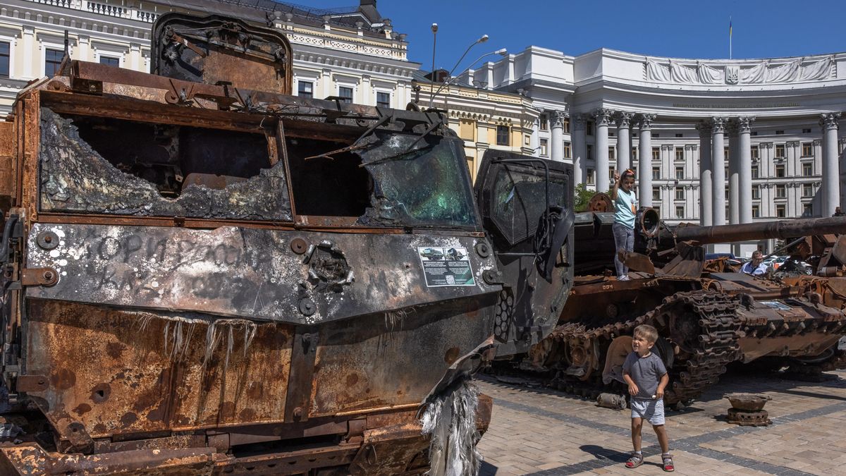 Niños ucranianos entre restos de vehículos militares. EFE/EPA/ROMAN PILIPEY