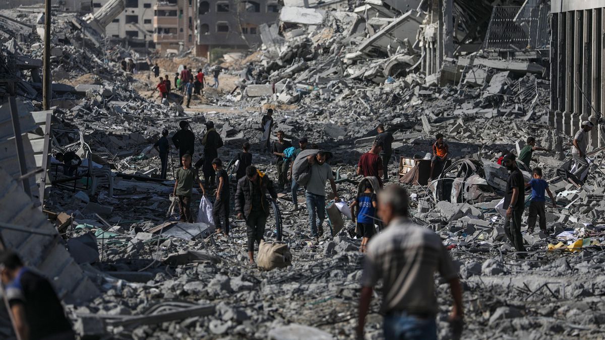 Palestinos caminan por una calle entre los escombros de los edificios destruidos durante un alto el fuego entre Israel y Hamás, en el marco de la primera fase del plan de paz para Gaza, en la Ciudad de Gaza.