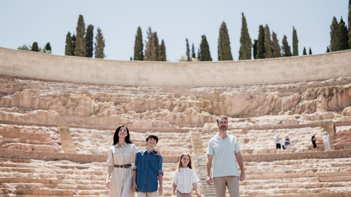 Una familia visita el Teatro Romano de Cartagena durante una estancia en la ciudad