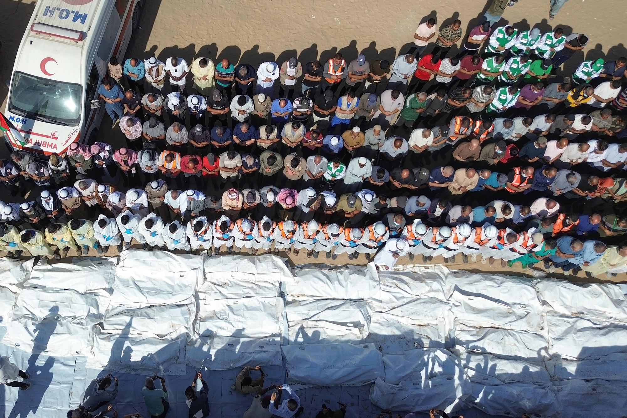 Los equipos médicos rezan ante los cuerpos de decenas de cadáveres de palestinos sin identificar entregados por Israel el 22 de octubre.