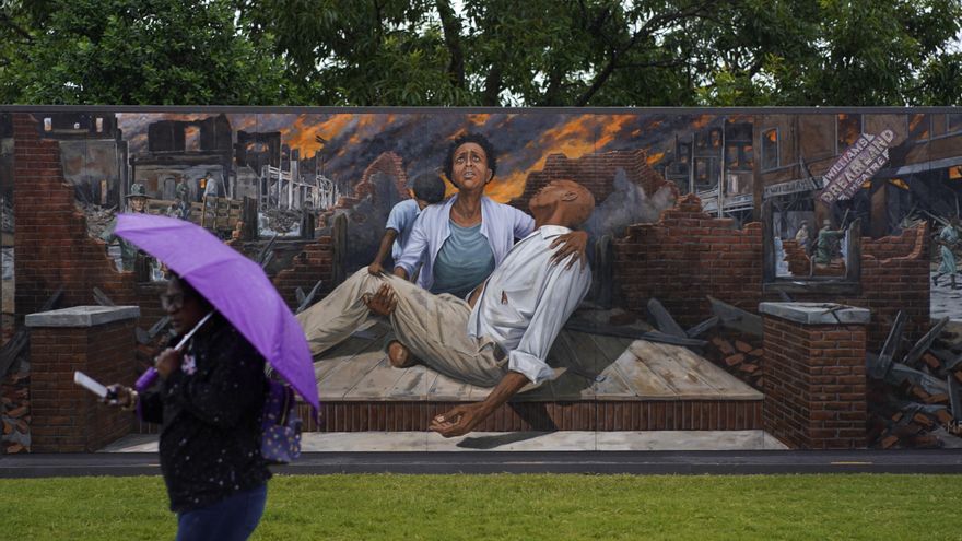 Una mujer camina junto a un mural que representa la masacre racista de Tulsa durante su centenario en mayo de 2021. Foto: AP Photo/John Locher