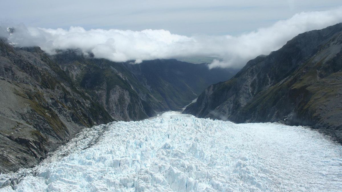Los visitantes caminan entre helechos gigantes y vegetación densa mientras escuchan el rugido de los ríos glaciares que nacen directamente del deshielo de las paredes de color azul