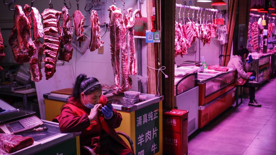 Beijing (China), 15/10/2020.- A vendor uses her mobile phone as she waits for consumers at a meat stall at a market in Beijing, China, 15 October 2020. According to the National Bureau of Statistics, China's Consumer Price Index (CPI), which is a main gauge of inflation, rose 1.7 percent year-on-year in September 2020. EFE/EPA/WU HONG
