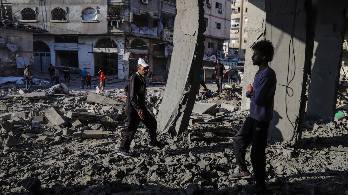 Palestinos inspeccionan un edificio destruido tras un ataque aéreo israelí en la calle Al Nasr de Ciudad de Gaza, al norte de la Franja de Gaza. EFE/ Mohammed Saber
