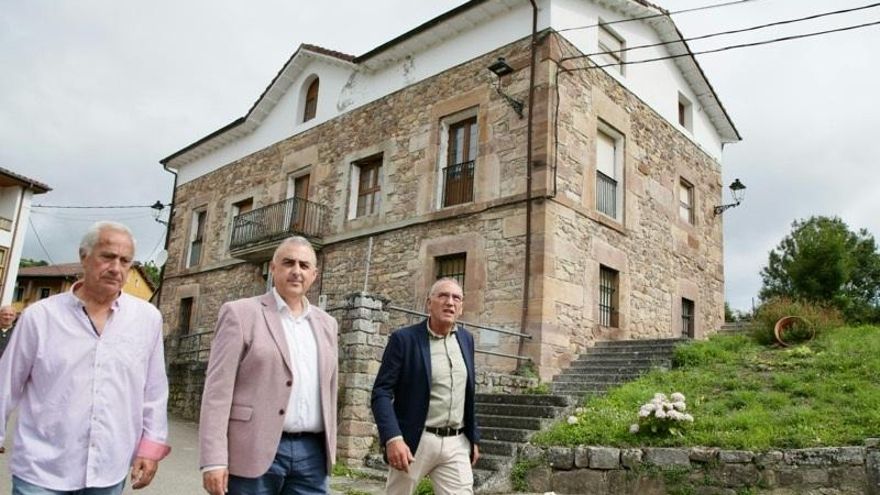 El consejero de Fomento, Roberto Media, en la fachada de las antiguas escuelas de Pesquera que se convertirán en viviendas en alquiler asequible