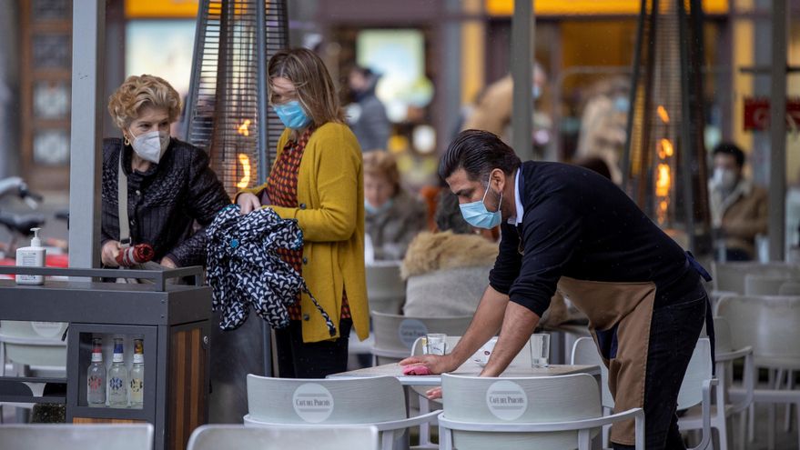 Un camarero desinfecta la mesa de una terraza en Gijón, Asturias, este domingo. EFE/ Alberto Morante