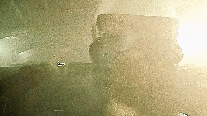 Los bomberos extienden el incendio de unas pacas en una estabulación de Sopeña