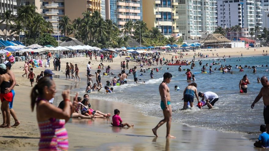 Decenas de personas disfrutan en una playa hoy, en el balneario de Acapulco, estado de Guerrero (México).