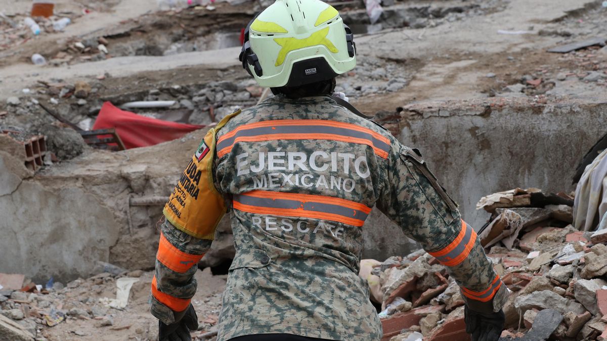 Una persona integrante del Ejercito de México realiza labores de búsqueda en los escombros de un edificio en La Guaira. 