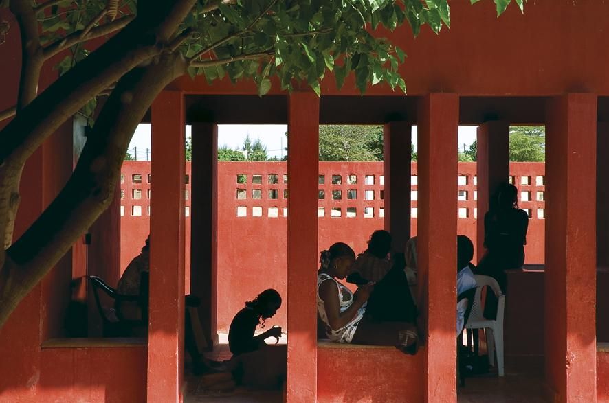 Hollmén, Reuter & Sandman, Centro de mujeres,Rufisque, Senegal, foto Helena Sandman El nuevo centro alberga un programa destinado a dar asistencia a las asociaciones de mujeres, pilares básicos de bienestar social en la sociedad africana. Su programa y diseño se ha consensuado con ellas. El edificio adopta un tipo edificatorio tradicional en el oeste de África: un recinto protegido por una cerca y cualificado al interior por un patio en torno al cual se despliegan los distintos ámbitos.