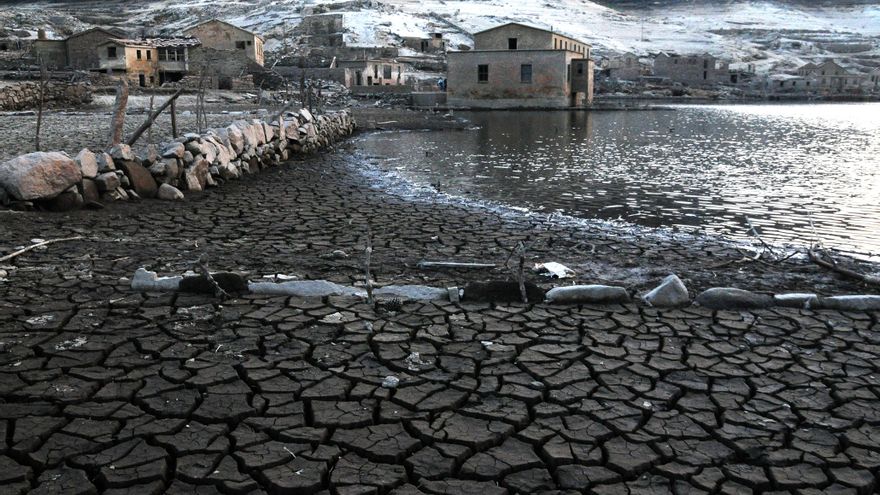 La tierra queda cuarteada al retirarse las aguas en el embalse. Siguen en pie muros de separación de terrenos y asoman troncos de parras.