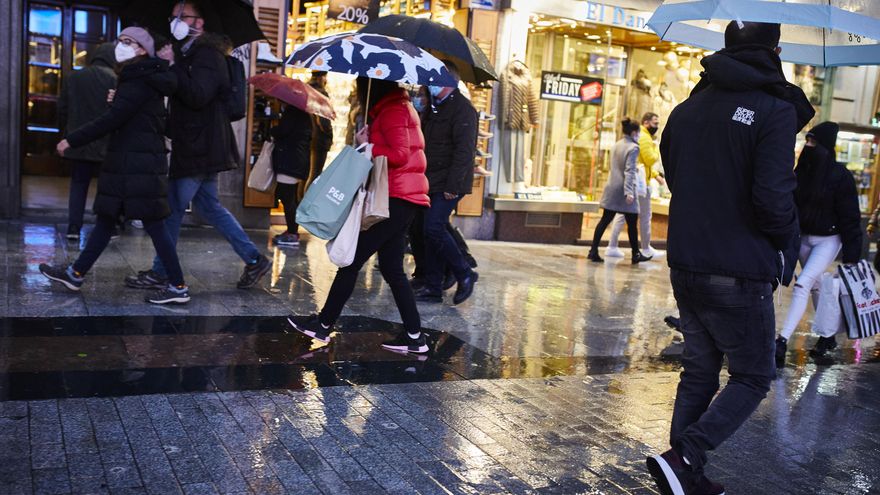 Archivo - Transeúntes caminan cerca de una zona comercial en la calle de Preciados, en Madrid