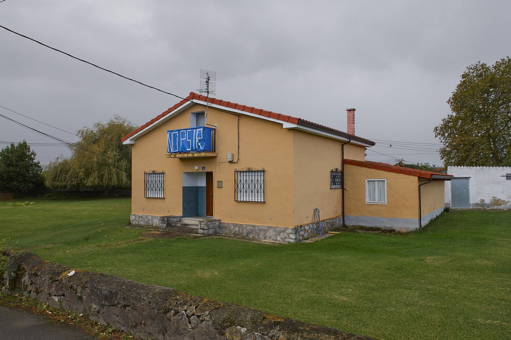 Una de las viviendas afectadas con un cartel contra el PSIR de Laredo.