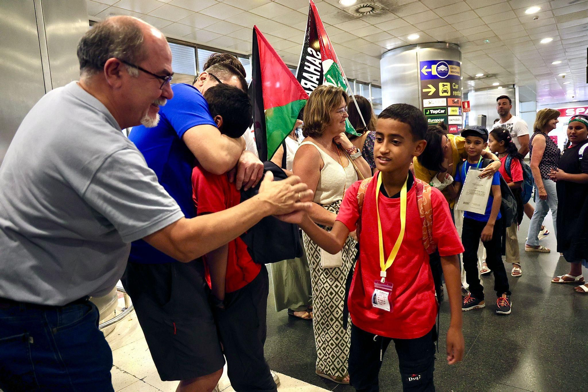 Personas esperando a los más pequeños en el aeropuerto de Gran Canaria, con banderas saharauis.