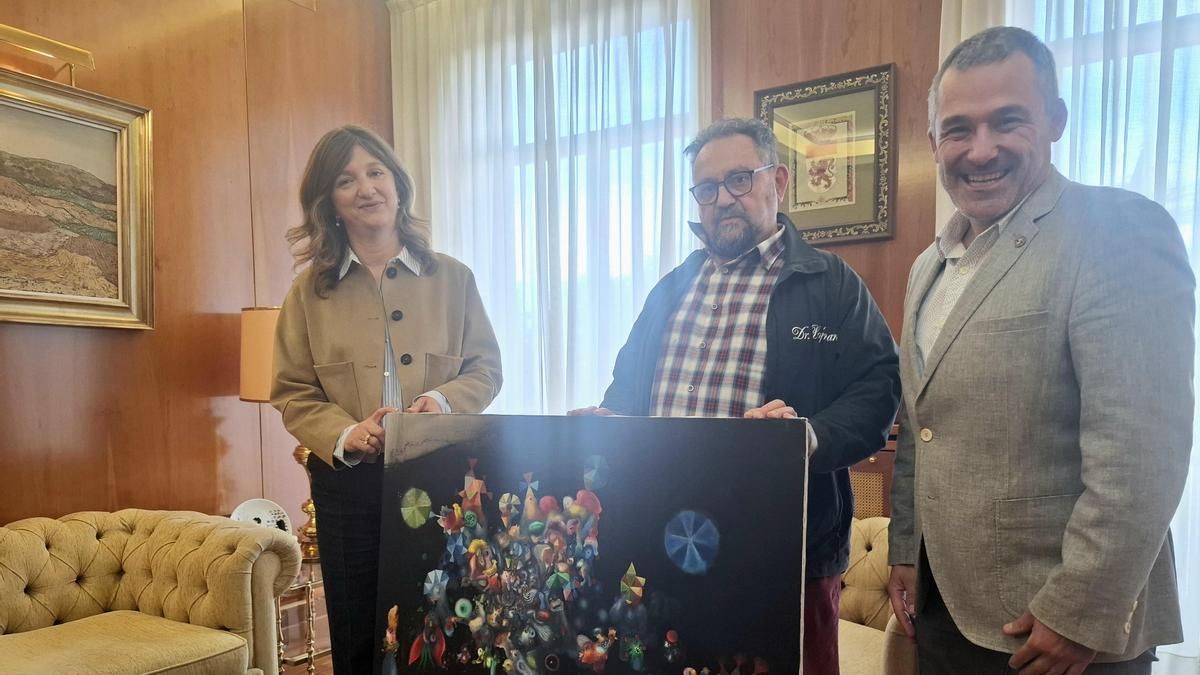 De izquierda a derecha, Nuria González, el pintor José de León y Diego Soto, con la obra donada por el autor.