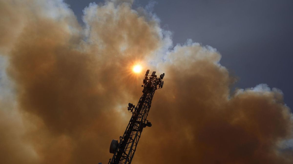 Columna de humo producida por el incendio que se mantiene activo en la localidad madrileña de Pelayos de la Presa, este viernes
