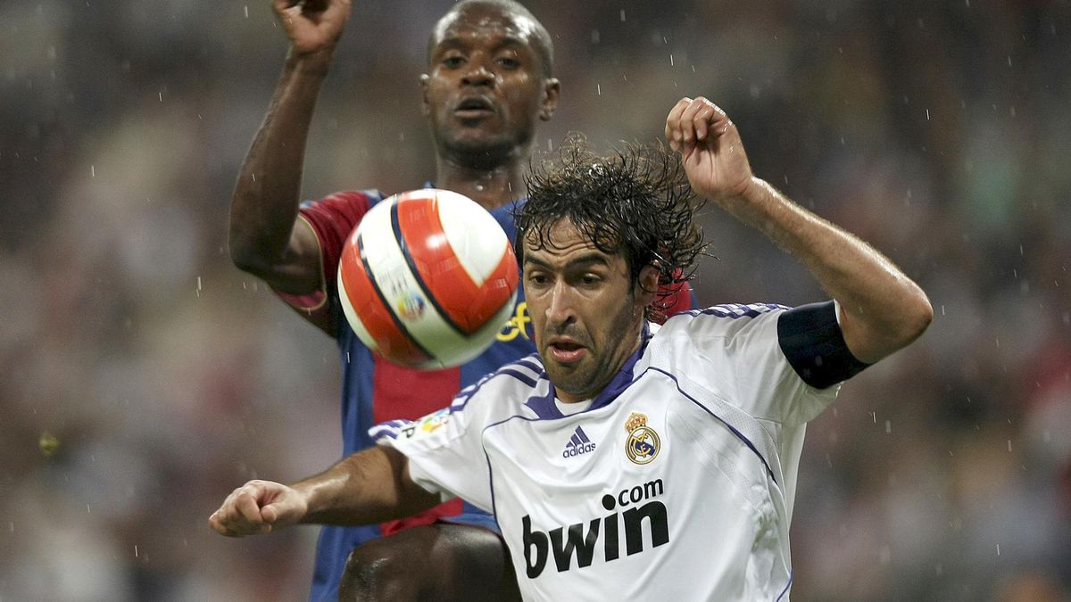 El delantero del Real Madrid, Raúl (d), intenta controlar el balón ante el defensor francés del F. C. Barcelona, Éric Abidal, durante el encuentro en el estadio Santiago Bernabeu del 7 de mayo de 2008.