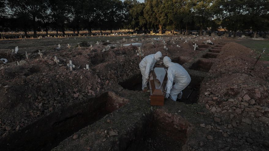 Dos sepultureros cargan un ataúd de una víctima de covid-19 durante su funeral en el cementerio de Caju en Río de Janeiro (Brasil). EFE/Antonio Lacerda/Archivo