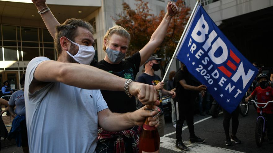 Dos partidarios de Biden descorchan una botella para celebrar su victoria en la ciudad de Filadelfia, tradicional bastión demócrata, en un estado, Pensilvania, que había votado por Trump en 2016