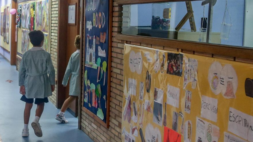 Varios niños entran a un aula escolar.