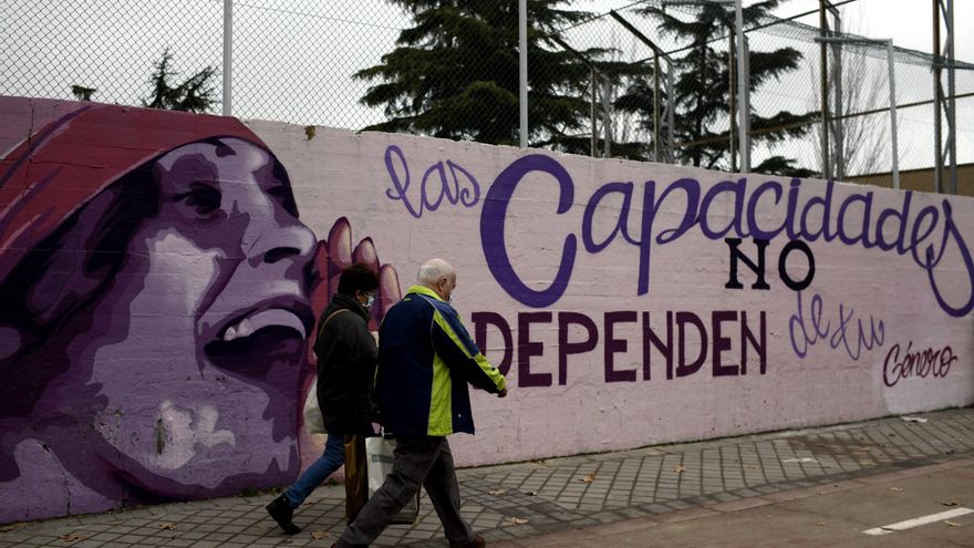 Dos personas pasan por el mural feminista en el polideportivo municipal de la Concepción en el distrito de Ciudad Lineal