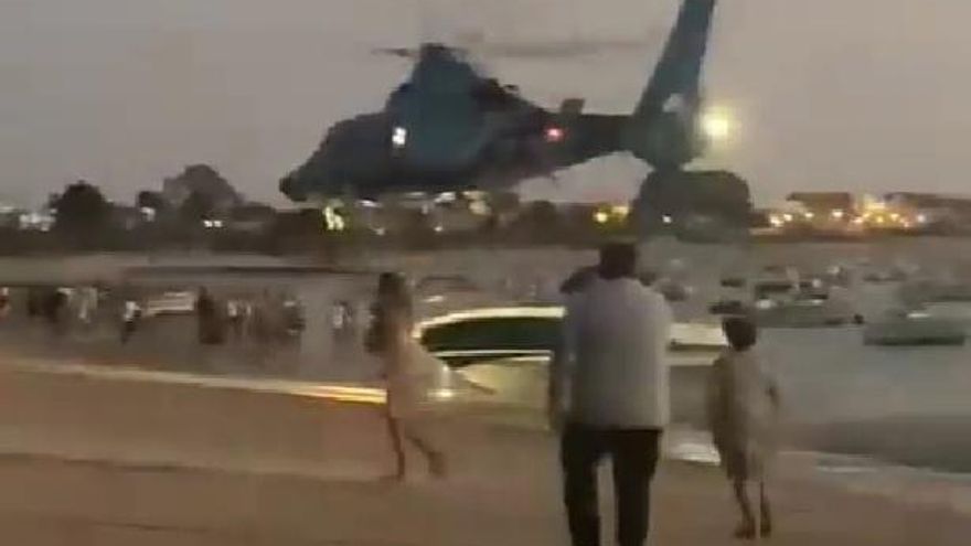 Un helicóptero de Aduanas aleja a los bañistas que querían coger la carga de una narcolancha en una playa de Cádiz