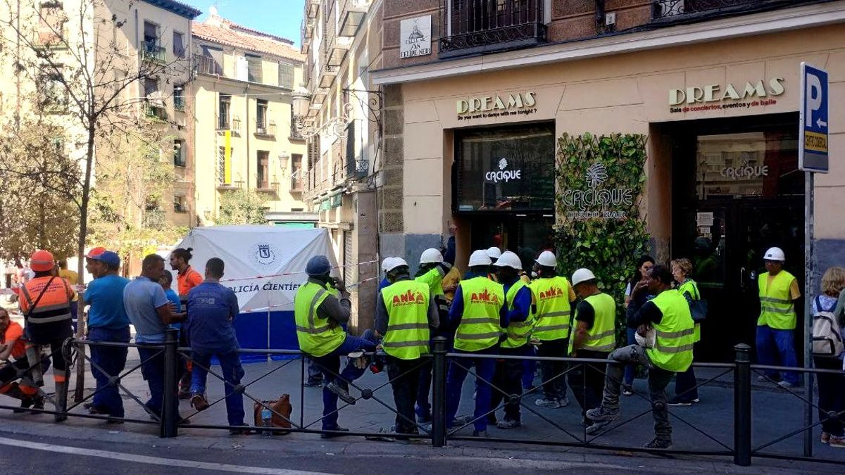 Varios obreros reunidos en los alrededores del número 4 de la calle Hileras, en Ópera, después de que se derrumbara una parte del edificio en el que trabajaban