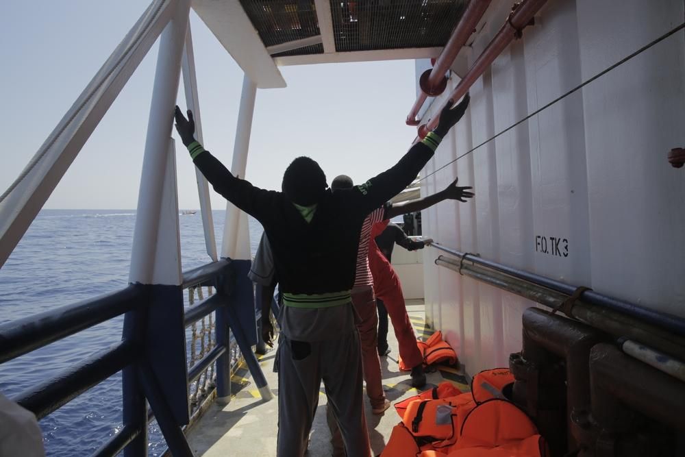 Un hombre celebra su llegada a bordo del Dignity I, uno de los buques de salvamento de MSF. El alivio que sienten al ser rescatados es e inmenso. La emoción es enorme y muchos la expresan de rodillas y con los brazos levantados para dar gracias y rezar por haber llegado sanos y salvos. Para algunos este momento supone el fin de una odisea de meses o incluso años. Fotografía: Agus Morales/MSF