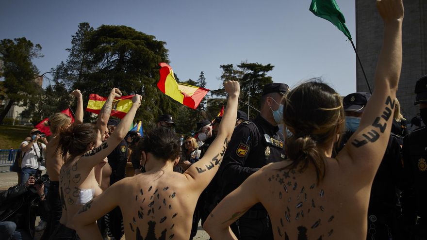 Varias activistas de Femen con águilas franquistas dibujadas en la espalda durante un acto por el Día de la Victoria en el LXXXII Aniversario de la “Liberación de Madrid”, en el Arco de la Victoria, en Madrid (España), a 28 de marzo de 2021.El colectivo a