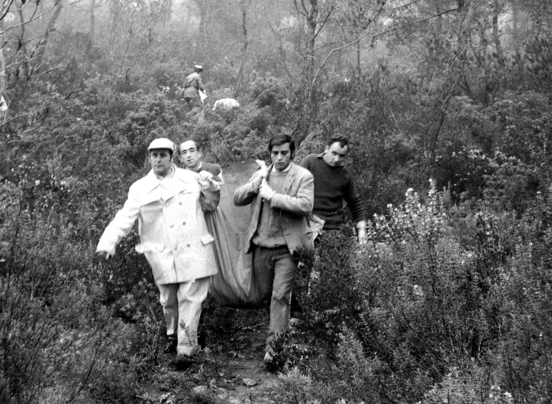 Miembros de la Guardia civil y personal de la Cruz Roja trasladan uno de los cadáveres rescatados en la zona donde se estrelló el avión de Iberia IB-602