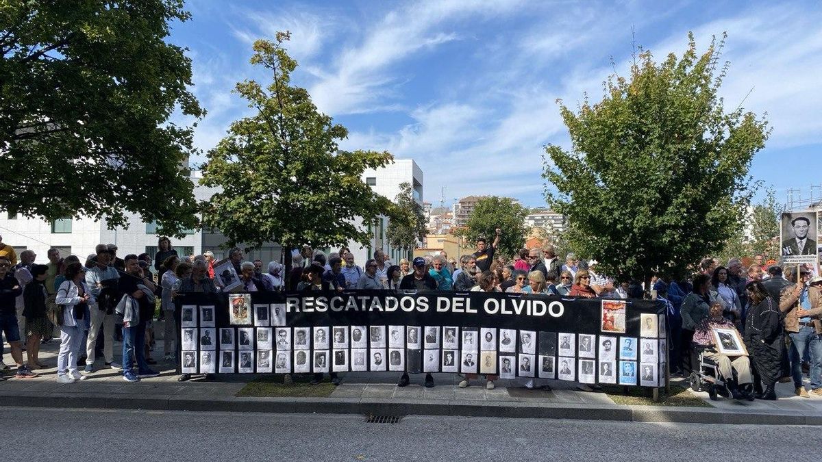 Miembros de la Plataforma Memoria y Democracia de Cantabria portan una pancarta con fotografías de represaliados.