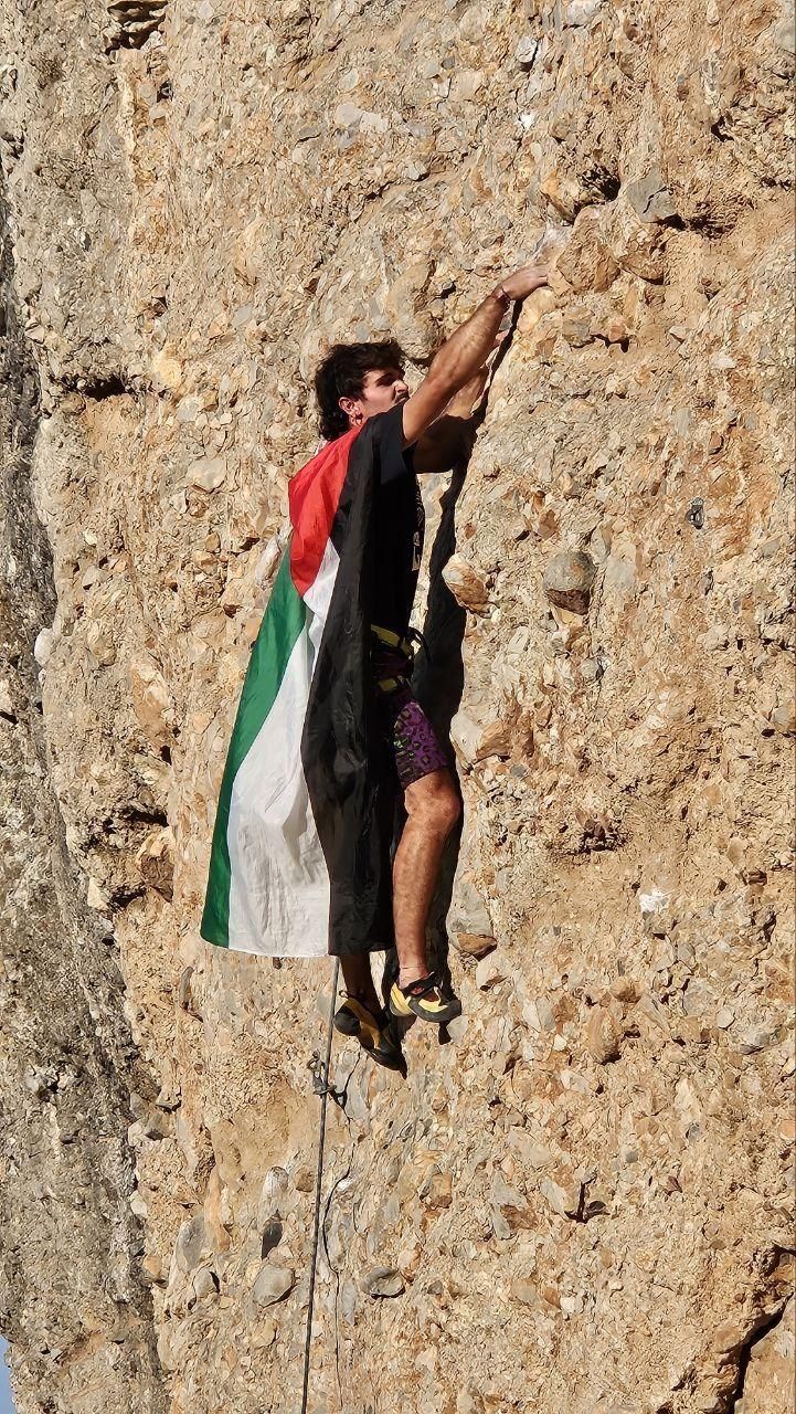 Un escalador con la bandera de Palestina