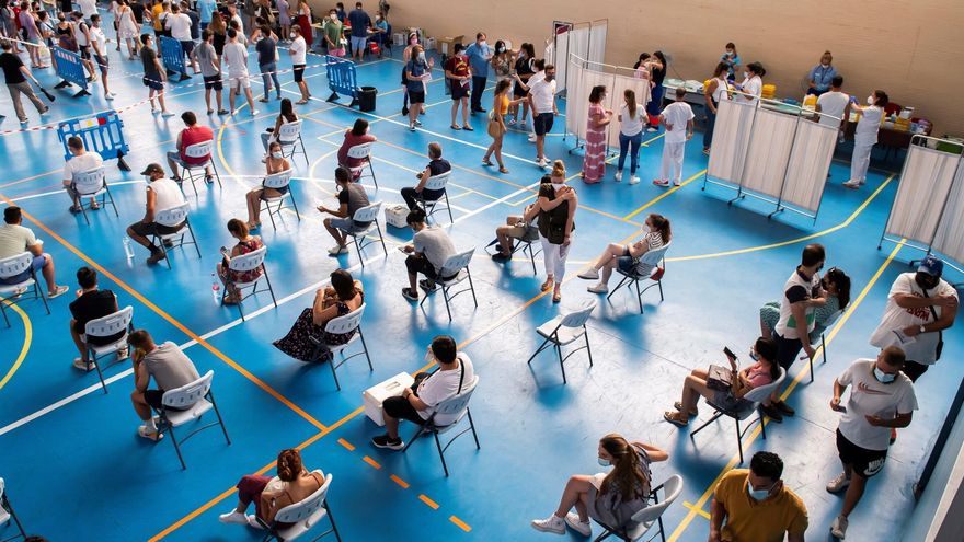 Multitud de jóvenes esperan su turno en el pabellón municipal de Espartinas (Sevilla) durante una vacunación masiva.