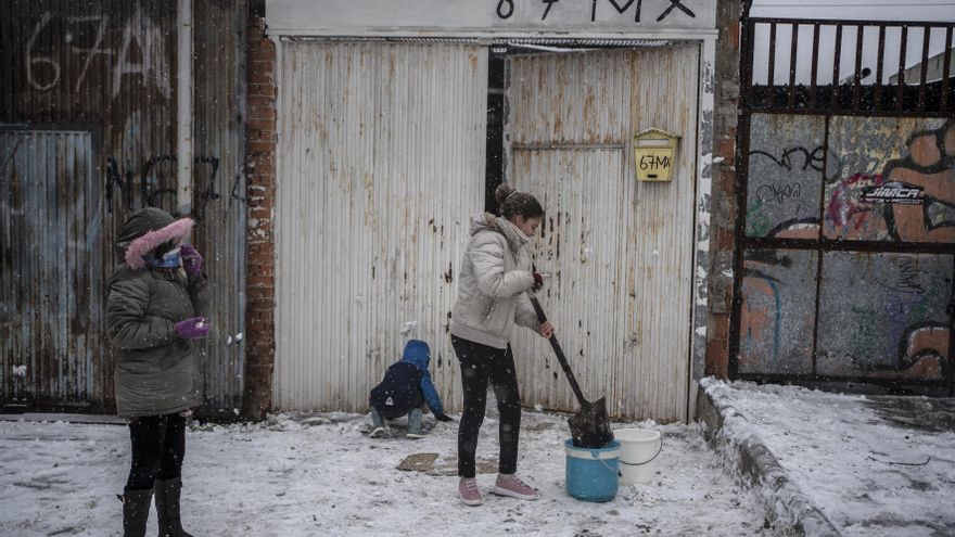 Omayma, de 13 años, limpia la nieve de la entrada de su casa con una pala. / OLMO CALVO