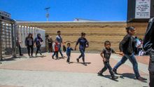 Decenas de migrantes, la mayoría con niños, retornan a territorio mexicano por la garita del chaparral, en la ciudad de Tijuana, del estado de Baja California (México).