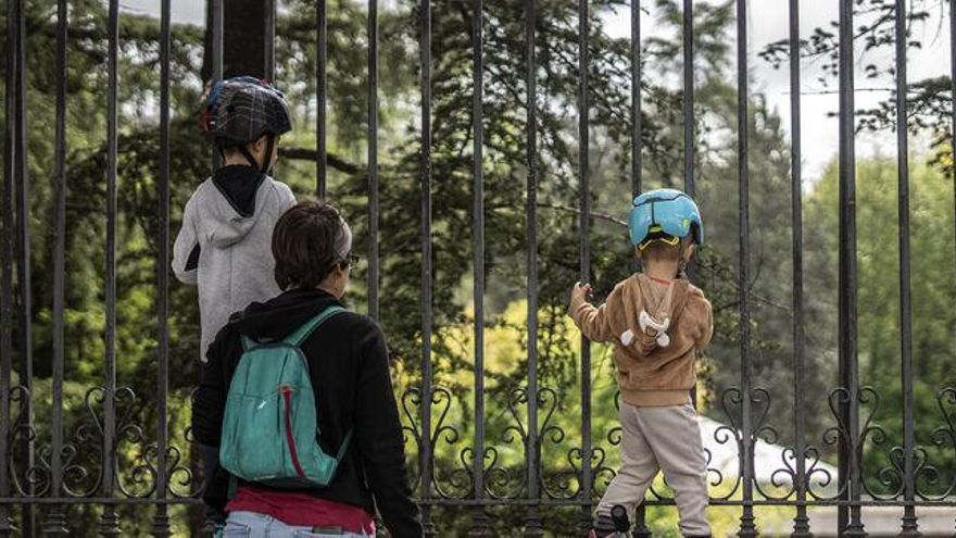 Madre e hijos exploran desde el exterior el Retiro