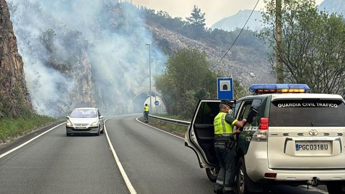Agentes de la Agrupación de Tráfico de la Guardia Civil se desplazaron a la AS 15 para regular la circulación tras la caída de piedras por un incendio cercano.