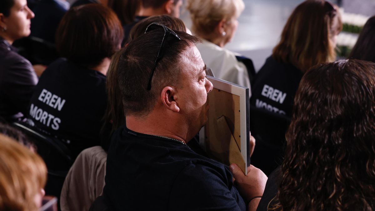 Momento en el que un familiar besa el retrato de una víctima de la dana