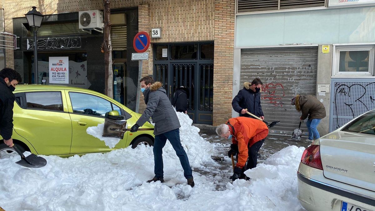 El presidente del PP, Pablo Casado, retira nieve de la acera, en Madrid
