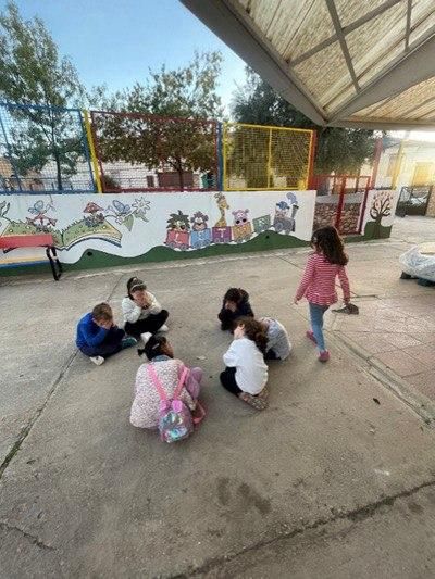 Niños y niñas jugando a la zapatilla por detrás en una de las actividades de la asociación 'Entre Todos'