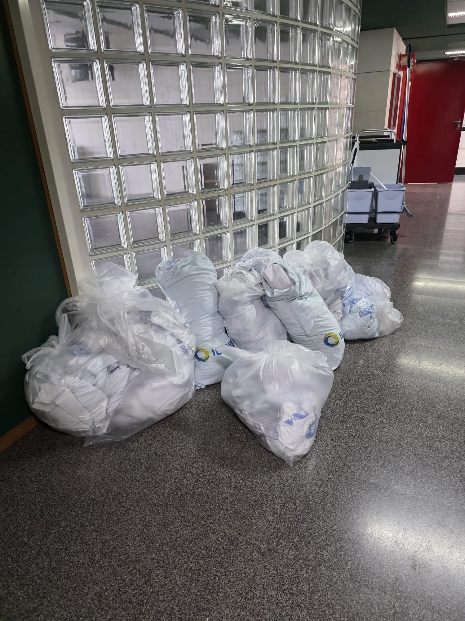 Bolsas de ropa amontonadas en los pasillos.