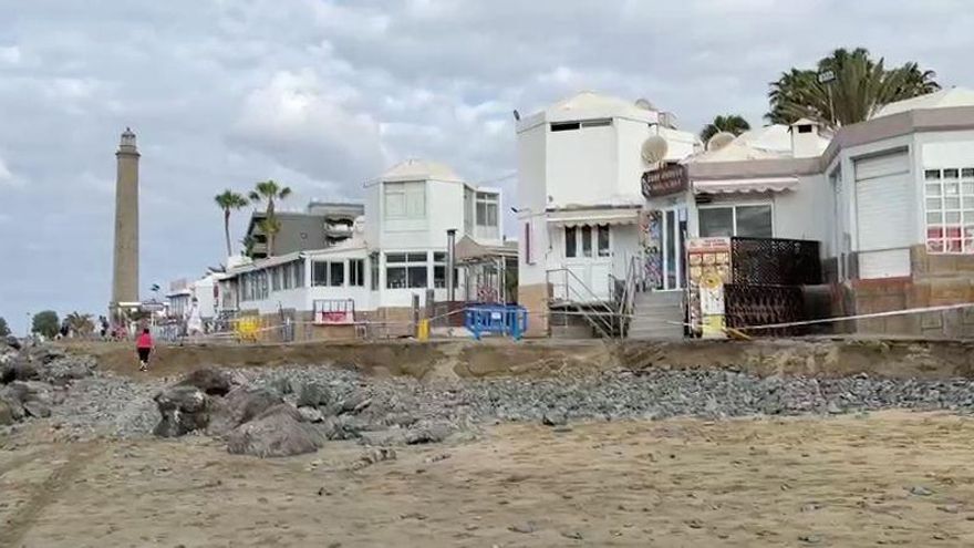 El mar se lleva parte del paseo de Maspalomas horas antes de la pleamar de luna llena y reaviva un histórica polémica en el litoral