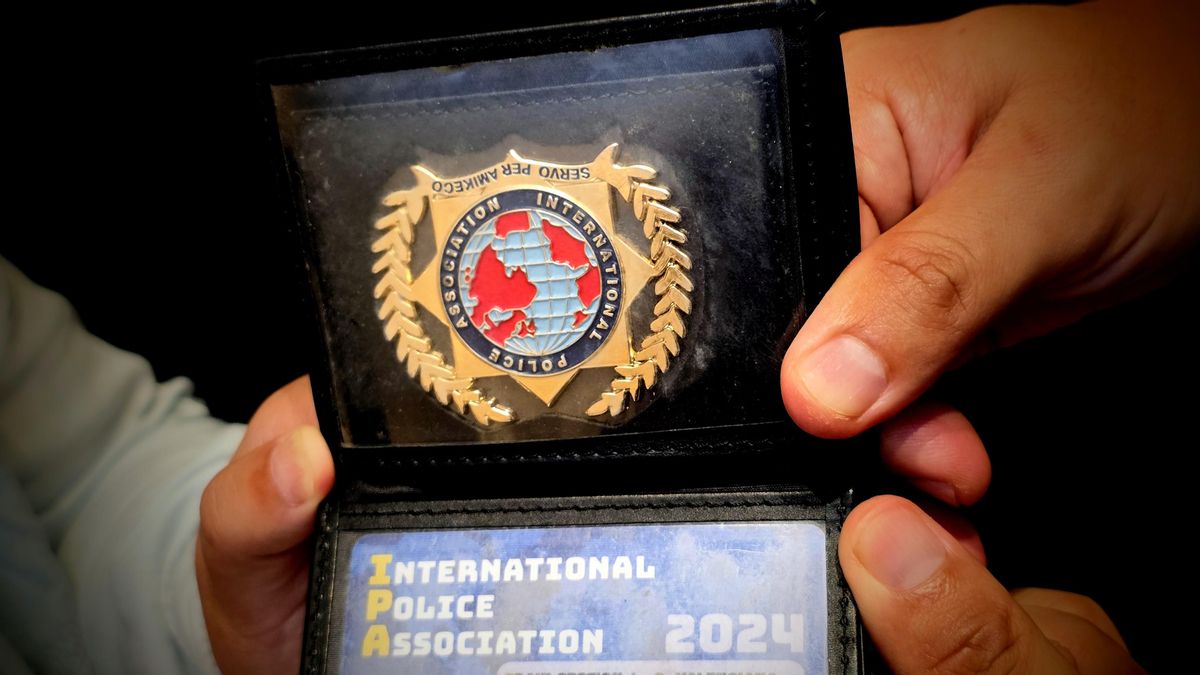 S. Y. y Z. W. sostienen una tarjeta de la Asociación Internacional de Policía.