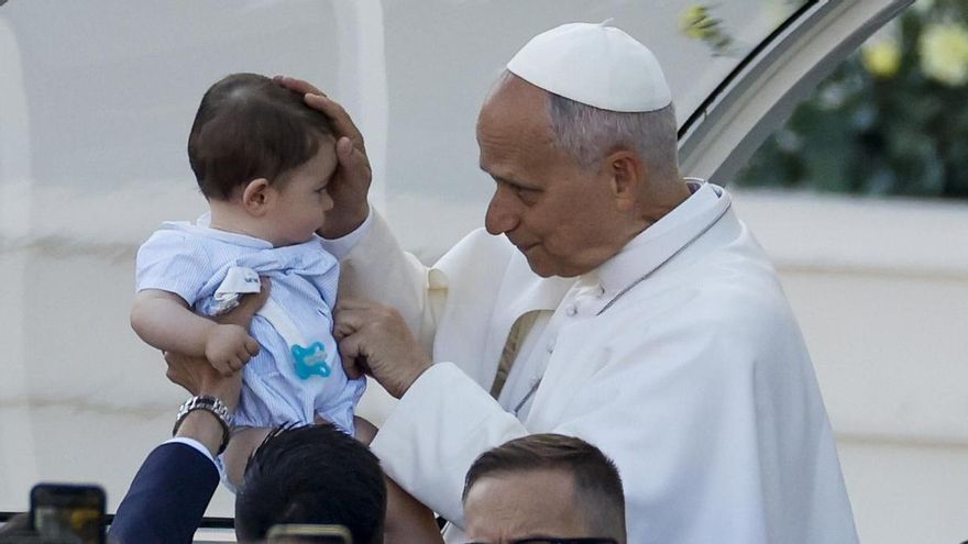El papa León XIV bendice a un niño durante la procesión del Corpus Christi tras la misa oficiada este domingo en la Plaza de Cibeles de Madrid.