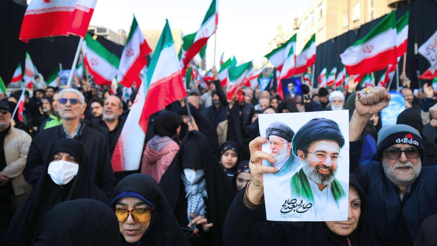 Manifestantes ondean banderas nacionales iraníes mientras se congregan en la plaza Enghelab, en el centro de Teherán.