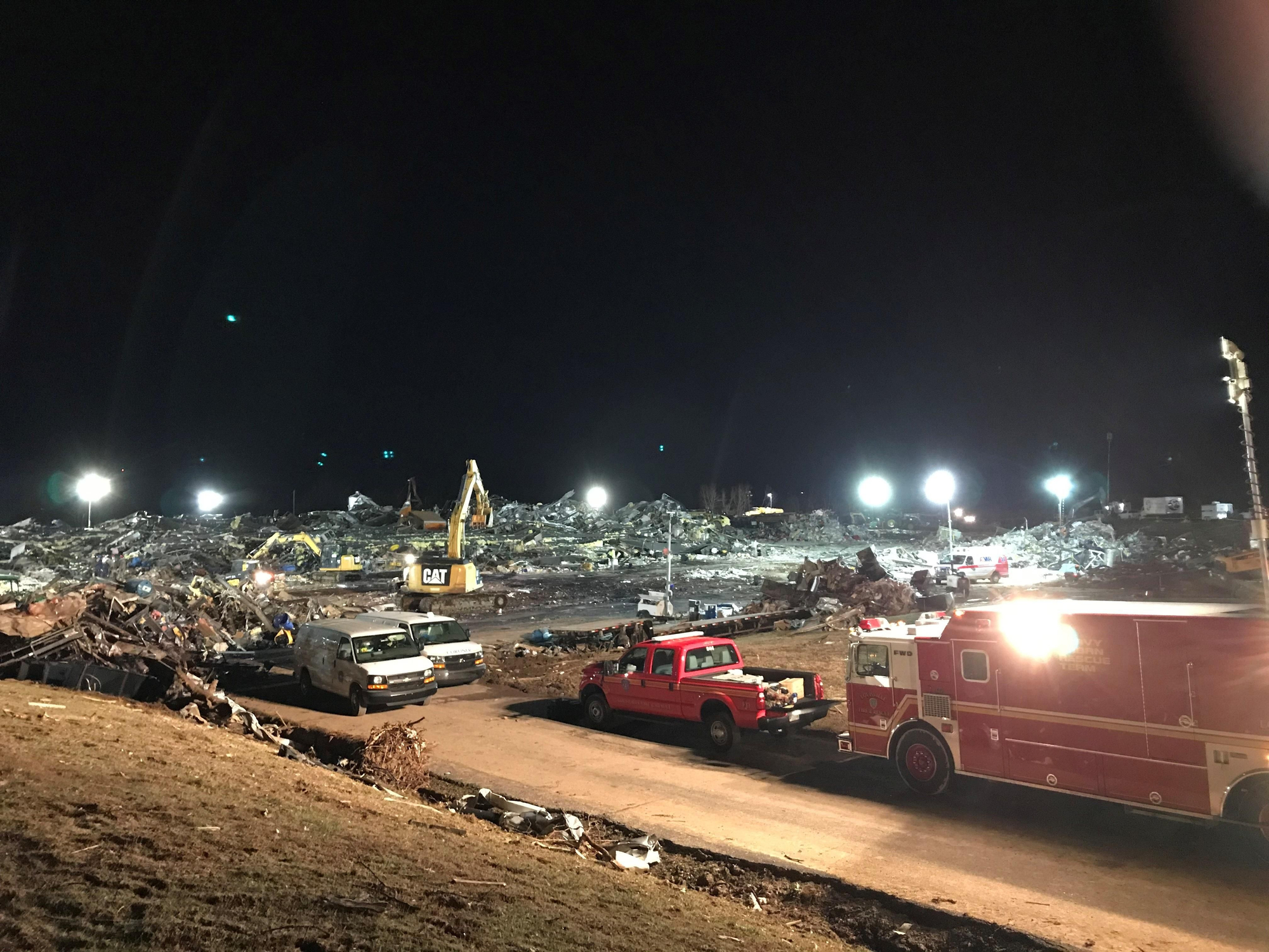 Bomberos y equipos de rescate trabajan la noche del sábado en el rescate de víctimas del tornado en Mayfield, Kentucky