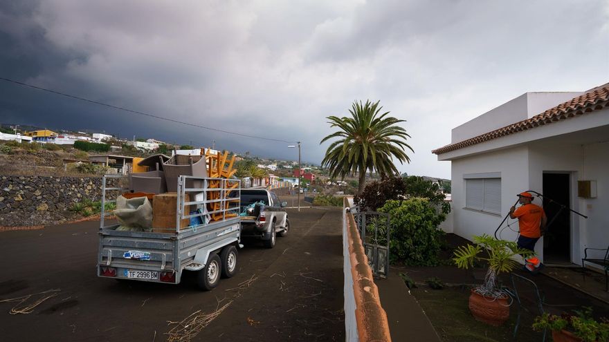 Personas sacando enseres de su vivienda antes de ser evacuada en La Palma