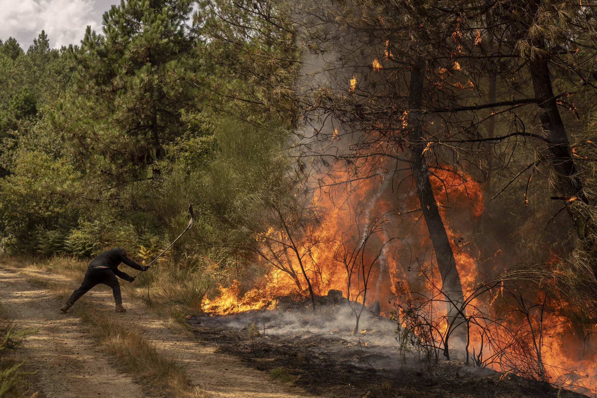 Un vecino lucha contra el fuego en la parroquia de As Mercedes (Ourense)